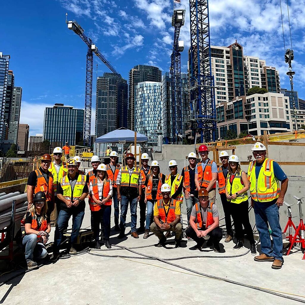 Exterior photo of group standing on roof of building in dense urban environment