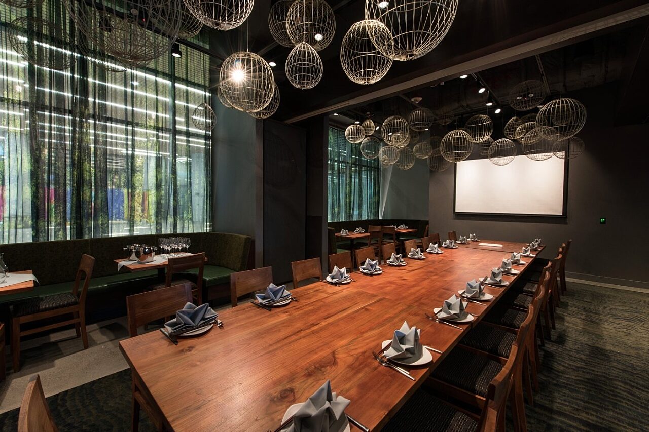 Large dining table with AV screen at Wild Ginger