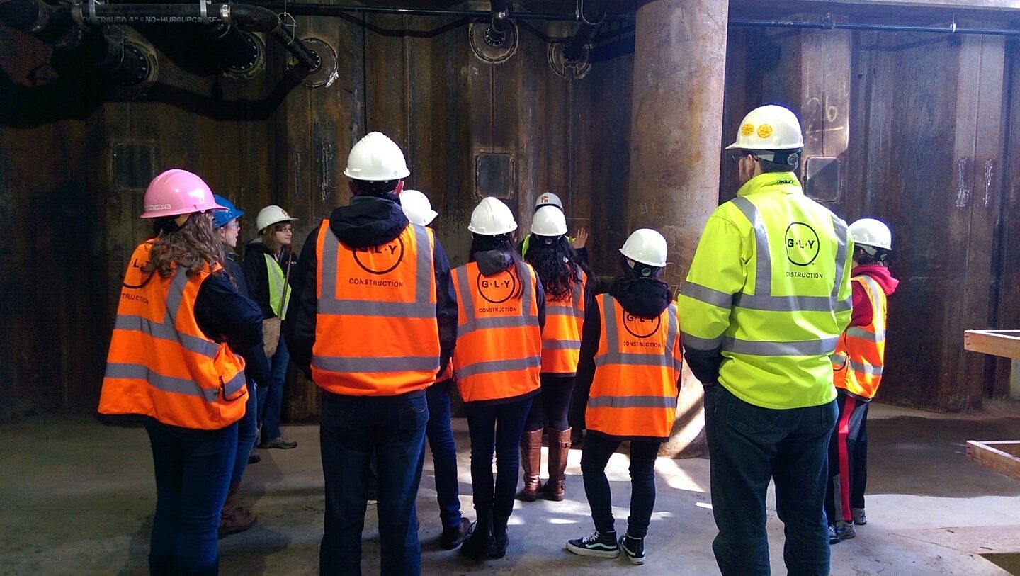 A group of children on a tour of a construction jobsite.