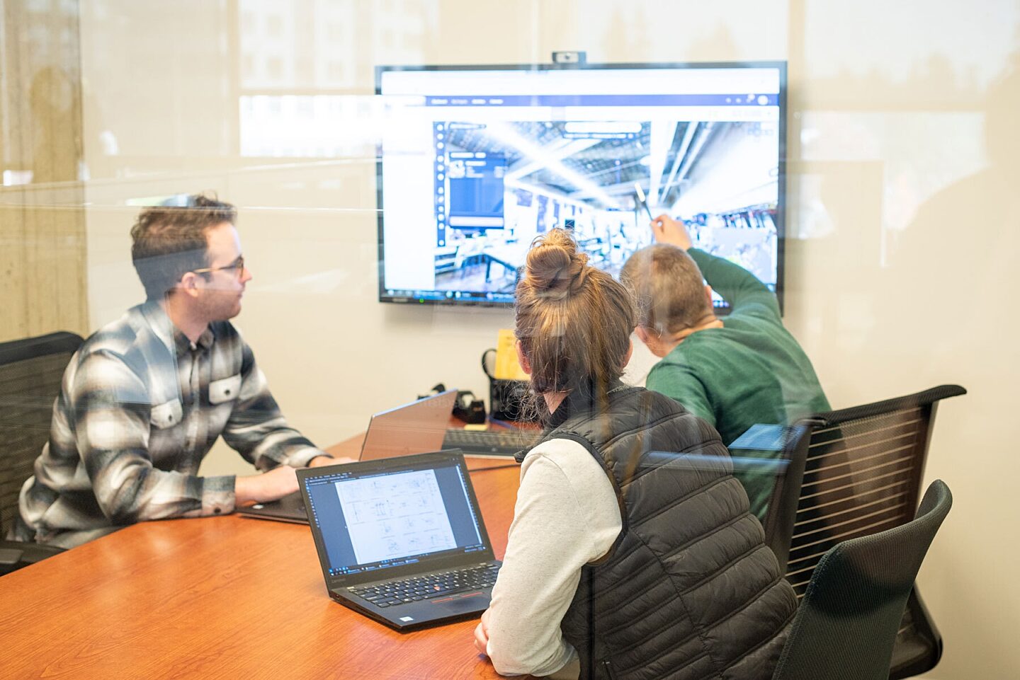 Project Team in meeting room discussing technical image on monitor