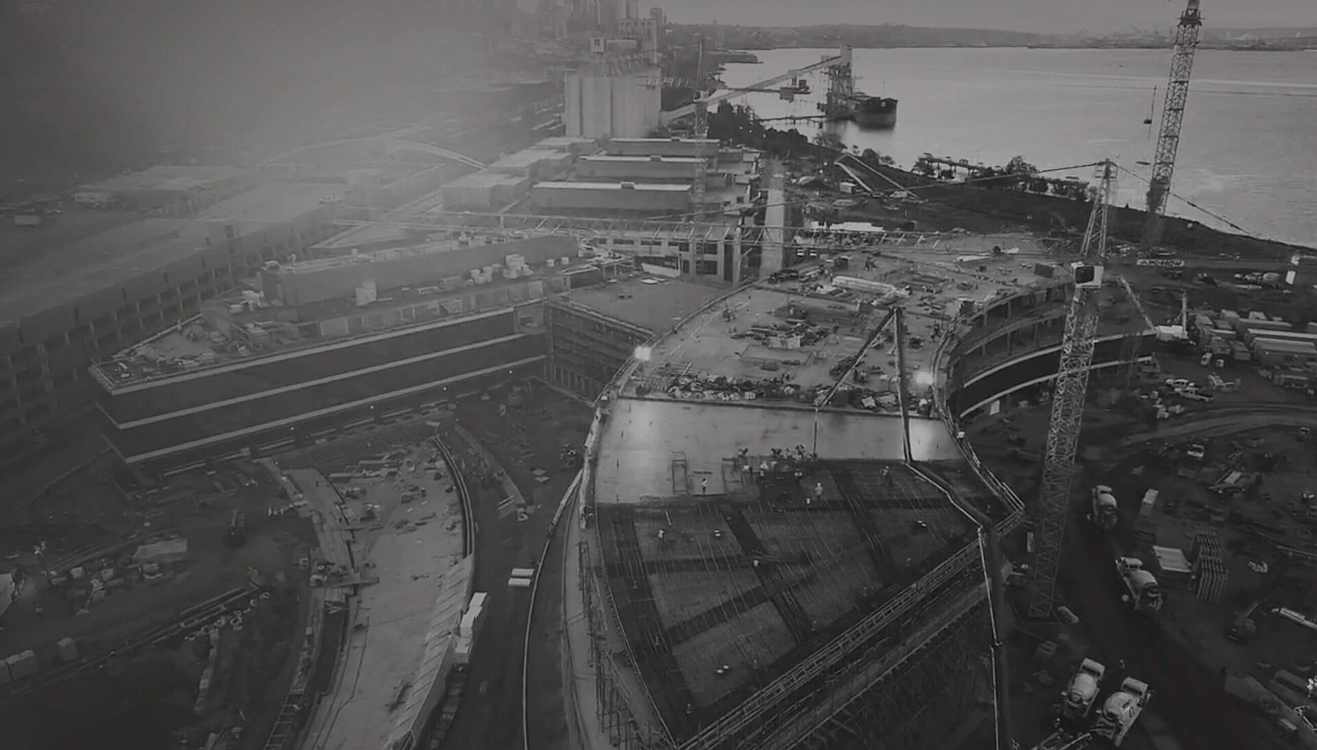 Darkened image of a construction site viewed from far above in a drone shot.