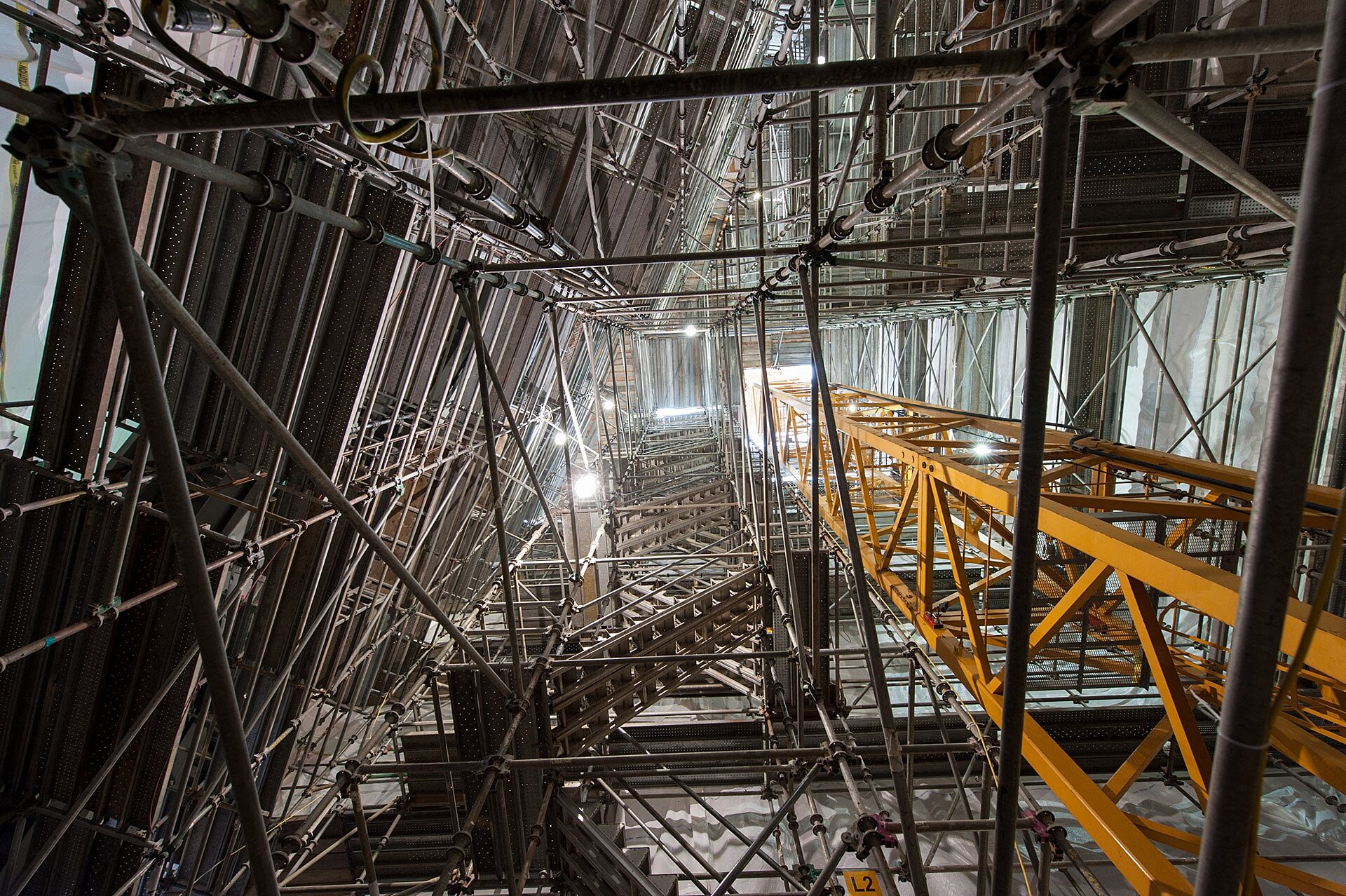 Worm's-eye perspective of tower crane surrounded by temporary stairs