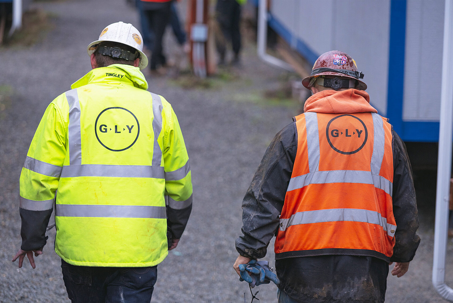 Back view of two construction workers walking on a jobsite.