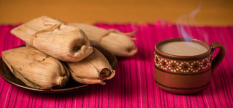 A Mexican meal of hot tamales and steaming cup of atole.