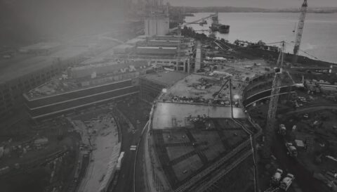 Darkened image of a construction site viewed from far above in a drone shot.