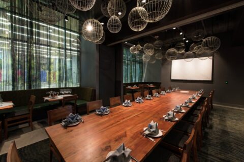 Large dining table with AV screen at Wild Ginger